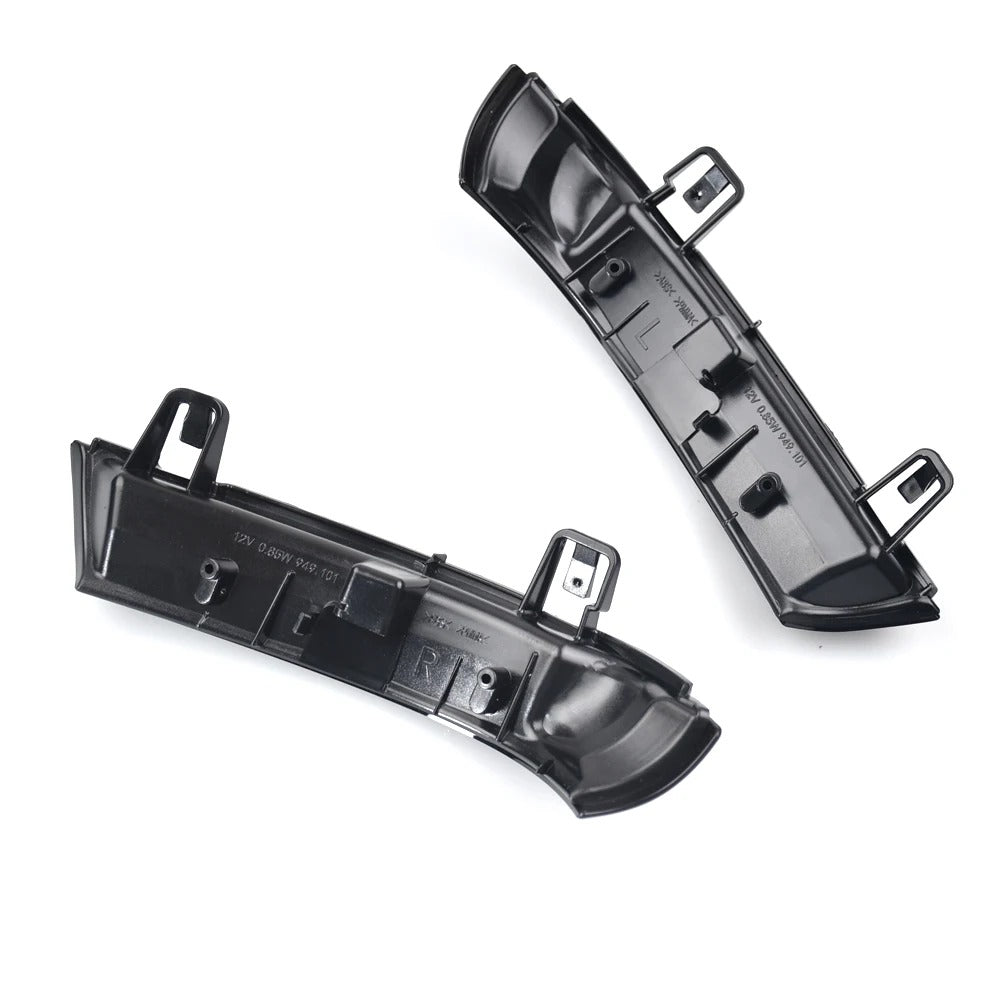 Two black plastic car parts on a white background