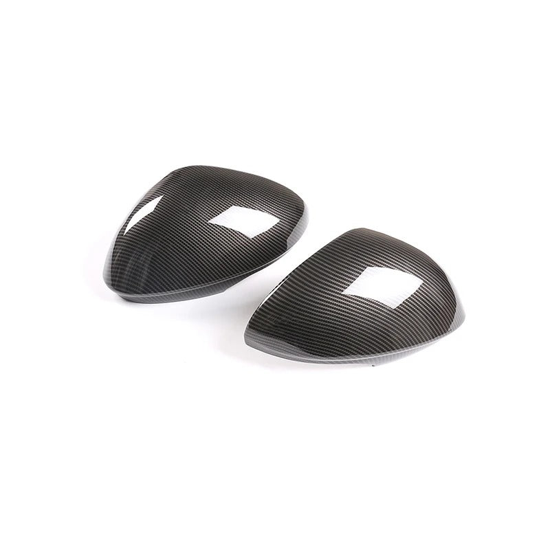 Two carbon fiber mirror coverings on a white background