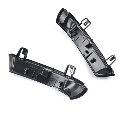 Two black plastic car parts on a white background
